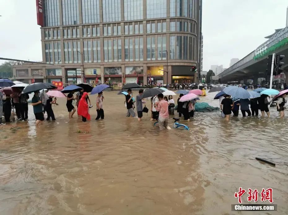 河南郑州，市民冒着暴雨出行