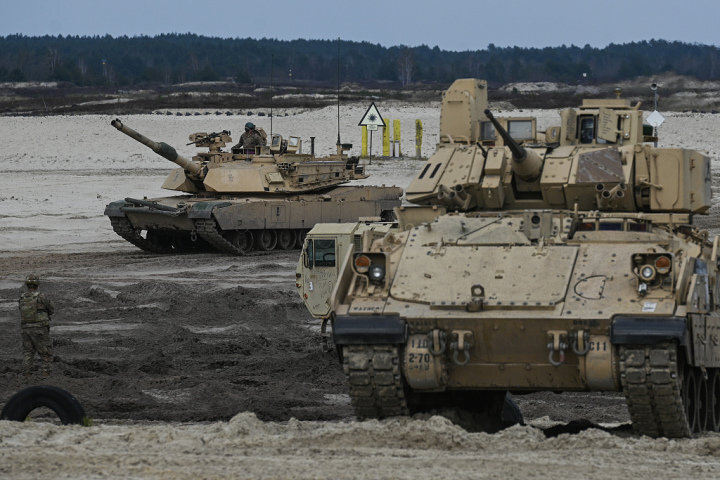 在波兰新登巴训练场上美军在操练M1A2坦克（左）和布拉德利战车（右）